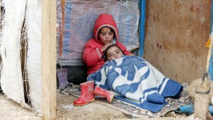 A Syrian refugee girl sits with her brother at a makeshift settlement in Bar Elias in the Bekaa valley