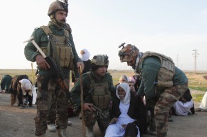 Kurdish security forces help people from the minority Yazidi sect, on the outskirts of Kirkuk