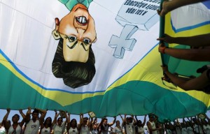 Demonstrators wave a flag with a draw of Brazil's President Dilma Rousseff during an anti-government demonstration in Copacabana in Rio de Janeiro