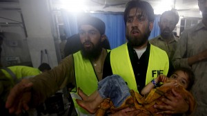 A child is taken to Leady Reading Hospital for treatment after torrential rains caused flooding and houses to collapse in Peshawar