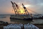 Rescue workers stand on the river bank as the capsized cruise ship Eastern Star is pulled out of the Yangtze against sunset, in Jianli, Hubei province, China, June 5, 2015. REUTERS/China Daily