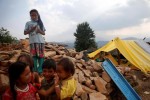 Children stand on the remains of houses which were destroyed by earthquakes in Sindhupalchowk district, Nepal, May 13, 2015. REUTERS/Ahmad Masood/Files