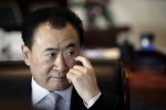 Wang Jianlin, chairman of Dalian Wanda Group, touches his face during an interview at his office in the company's headquarters in Beijing in this December 3, 2012 file photo. Chinese property developer Dalian Wanda Group says it can afford to spend as much as $5 billion every year to buy foreign firms or assets, underscoring the rising clout of the firm as it expands abroad. To match Interview CHINA-WANDA/  
 REUTERS/Suzie Wong/Files (CHINA - Tags: BUSINESS PROFILE HEADSHOT REAL ESTATE CONSTRUCTION)