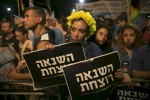 A woman holds signs during a protest against the violence towards the gay community in Tel Aviv August 1, 2015. Thousands came to show solidarity after an ultra-Orthodox Jewish man stabbed and wounded six participants, two of them seriously, in the annual Gay Pride parade in Jerusalem on Thursday, with police saying the suspect was jailed for a similar attack 10 years ago. The sign reads "hatred kills".  REUTERS/Baz Ratner      TPX IMAGES OF THE DAY      - RTX1MOY9