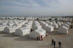 Syrian refugees who fled violence in Syrian city of Ain al-Arab, known also as Kobani, seen outside their tents in a camp in the border town of Suruc, Turkey, Monday, Feb. 2, 2015. About 200,000 people arrived in Turkey since the start of fighting between Kurdish militia and Islamic State militants mid-September, 2014.(AP Photo/Emrah Gurel)