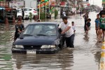 Iraqis push a car, submerged in water, as others make their way through a flooded street after heavy rain fell in Baghdad, Iraq, Thursday, Oct. 29, 2015. Rain storms began late day Wednesday and continued through the morning Thursday, dumping heavy rain on the Iraqi capital and across the country. The Iraqi government declared Thursday a holiday to ease the burden on people who may otherwise struggle to get to work. (AP Photo/Karim Kadim)