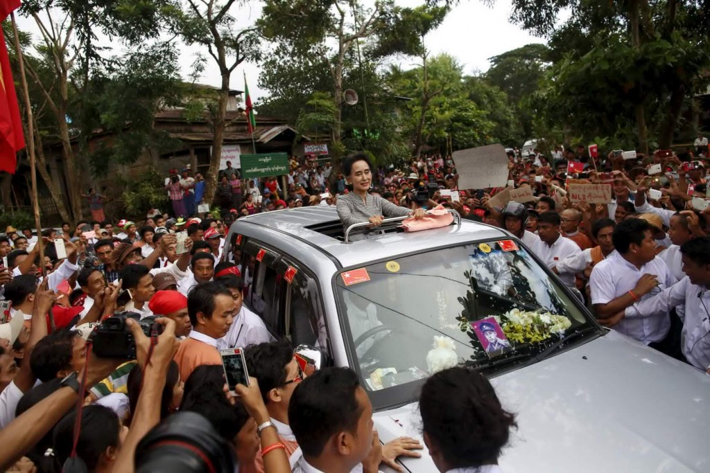 Myanmar pro-democracy leader Aung San Suu Ky smiles as she greets her supporters during her campaign in her constituency of Kawhmu township outside Yangon September 21, 2015. Suu Kyi was touring her constituency on the outskirts of Myanmar's commercial capital of Yangon on Monday, kicking off the third week of campaigning for the first free national vote in 25 years. REUTERS/Soe Zeya Tun - RTS251B