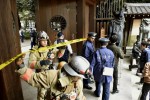 Police officers and fire fighters investigate at the south gate of Japan's controversial Yasukuni Shrine where there was an explosion and burned the ceiling and wall of the public bathroom, in Tokyo, Japan, in this photo taken by Kyodo November 23, 2015.  REUTERS/Kyodo