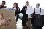 Community members hold signs during a news conference in the Astoria section of the Queens borough of New York, Thursday, Dec. 10, 2015. The news conference was called to express opposition to hate crimes and rhetoric, particularly in light of a recent attack in the neighborhood that police are investigating as a hate crime. (AP Photo/Seth Wenig)