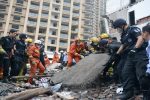 Rescue workers search at the site where residential buildings collapsed in Wenzhou, Zhejiang province, China, October 10, 2016. China Daily/via REUTERS ATTENTION EDITORS - THIS IMAGE WAS PROVIDED BY A THIRD PARTY. EDITORIAL USE ONLY. CHINA OUT. NO COMMERCIAL OR EDITORIAL SALES IN CHINA.      - RTSRJHY