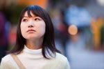 Outdoor portrait of a sad but beautiful looking young Asian woman