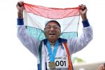 TOPSHOT - 101-year-old Man Kaur from India celebrates after competing in the 100m sprint in the 100+ age category at the World Masters Games at Trusts Arena in Auckland on April 24, 2017. / AFP PHOTO / MICHAEL BRADLEY        (Photo credit should read MICHAEL BRADLEY/AFP/Getty Images)