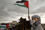 A Palestinian waves a flag near a destroyed section of the border wall between the Gaza Strip and Egypt January 29, 2008. Israel will not stand in the way of Palestinian President Mahmoud Abbas taking control of Gaza's breached border with Egypt as part of a deal to sideline Hamas Islamists who rule the enclave, officials said on Tuesday. REUTERS/Suhaib Salem (GAZA) - RTR1WFK6