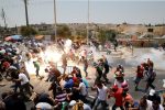 Palestinians react following tear gas that was shot by Israeli forces after Friday prayer on a street outside Jerusalem's Old city July 21, 2017. REUTERS/Ammar Awad