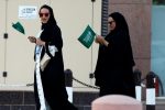 Saudi women hold national flags as they walk on a street during Saudi National Day in Riyadh, Saudi Arabia, September 23, 2016. REUTERS/Faisal Al Nasser  - RTSP5KW