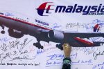 A woman writes a message on a board for passengers onboard missing Malaysia Airlines Flight MH370 and their family members, at Dataran Merdeka in Kuala Lumpur March 22, 2014. Two weeks after the airliner went missing with 239 people on board, officials are bracing for the "long haul" as searches by more than two dozen countries turn up little but frustration and fresh questions.  REUTERS/Samsul Said (MALAYSIA - Tags: DISASTER TRANSPORT)