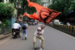 A man waves a flag as he blocks a road during a protest, organised by Maharashtra state's Maratha community, to press their demands for reserved quotas in government jobs and college places for students in Mumbai, India July 25, 2018. REUTERS/Danish Siddiqui      TPX IMAGES OF THE DAY