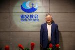 FILE PHOTO: The head pastor of the Zion church in Beijing Jin Mingri poses for picures in the lobby of the unofficial Protestant "house" church in Beijing, China, August 28, 2018.  Picture taken August 28, 2018.  REUTERS/Thomas Peter