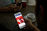 FILE PHOTO  - A cellphone user looks at a Facebook page at a shop in Latha street, Yangon, Myanmar August 8, 2018.  REUTERS/Ann Wang