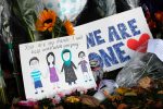 A message card is placed at a collection of flowers left at the Botanical Gardens in Christchurch, New Zealand, Saturday, March 16, 2019. New Zealand's stricken residents reached out to Muslims in their neighborhoods and around the country on Saturday, in a fierce determination to show kindness to a community in pain as a 28-year-old white supremacist stood silently before a judge, accused in mass shootings at two mosques that left dozens of people dead. (AP Photo/Vincent Thian)