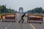 NEW DELHI, INDIA - MARCH 22: Indian policemen push barricades to place them in the center of a a road leading to historic India Gate,  during a one-day nationwide Janata (civil) curfew imposed as a preventive measure against the COVID-19 on March 22, 2020 in New Delhi, India. Death toll due to coronavirus in India reached seven on Sunday with three more fatalities as the country observed a "janta curfew" or public lockdown on the appeal of Prime Minister Narendara Modi. Besides placing under lockdown till March 31st, 75 districts with confirmed coronavirus cases , the government also decided to shut down train, metro and inter-state services to curb the spread of the global pandemic in India. (Photo by Yawar Nazir/Getty Images)