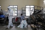 Medical health workers put on Personal Protective Equipment (PPE) as they get ready to work at a school that was turned into a centre for conducting tests for the coronavirus disease (COVID-19) amidst the spread of the disease, in New Delhi, India June 23, 2020. REUTERS/Anushree Fadnavis