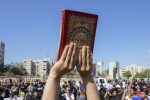 Supporters of the Shiite cleric Muqtada al-Sadr raises of the Quran, the Muslims' holy book, during a demonstration in front of the Swedish embassy in Baghdad in response to the burning of Quran in Sweden, Baghdad, Iraq, Friday, June 30, 2023. (AP Photo/Hadi Mizban)