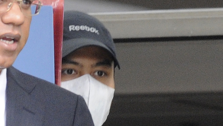 File photo of a masked Pyi Kyaw Han in a cap leaving the Subordinate Courts with his lawyer. Pyi, 31, and Louis Lee Lip Kian, 32, both Singaporeans, pleaded guilty to the offence in court to having sex with the Singaporean girl who was not yet 18 at the time of their offences between November and December 2010. -- ST PHOTO: ASHLEIGH SIM