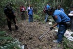 Security forces and rescue workers inspect a mass grave at a rubber plantation near a mountain  in Thailand's southern Songkhla province May 7, 2015. REUTERS/Surapan Boonthanom